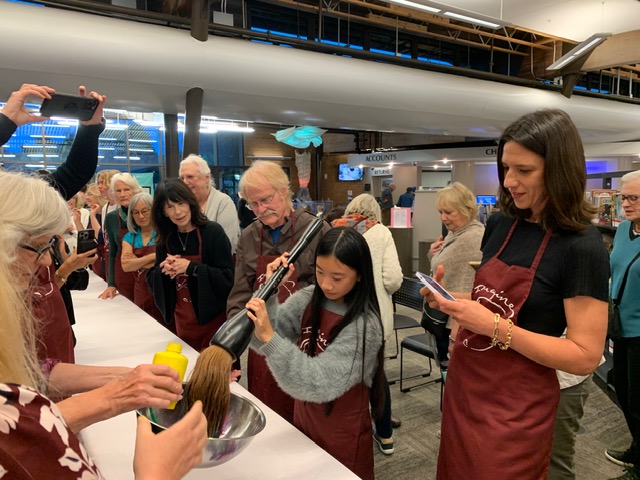A longtime student, Mia Yi, finding harmony with the giant brush. In Zen art, it is not the brush that creates the work, but the stillness, intention, and spirit behind each stroke.